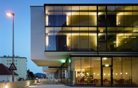 Modern hotel building with glass fa&ccedil;ade at dusk.