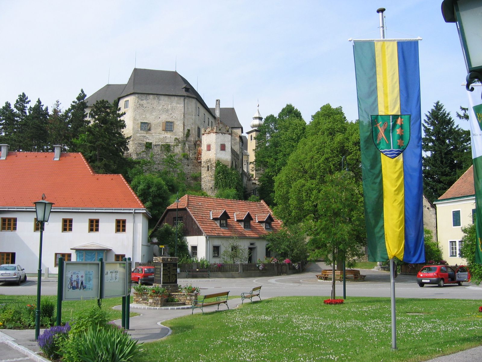 Main square in Albrechtsberg with castle in the background and flag in the foreground.