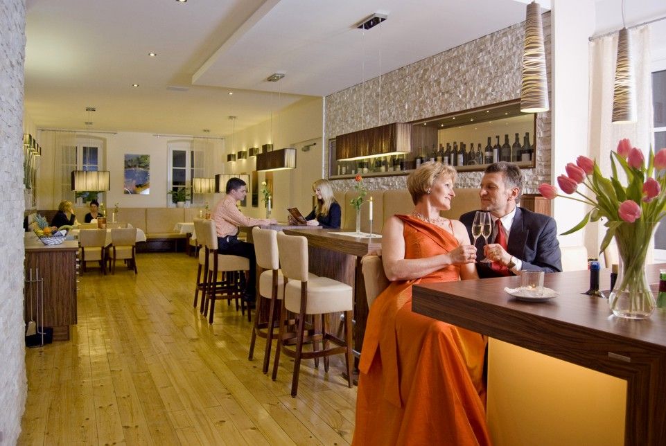 An elegant restaurant with couples tables and a bar.