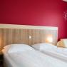 Bedroom with double bed and red wall
