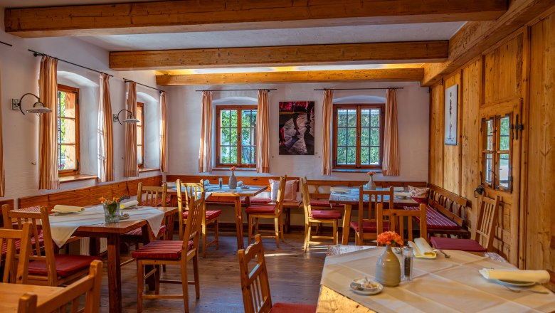 Cozy dining room with wooden furniture and laid tables.
