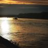 Sunset over a river with a boat in the background.