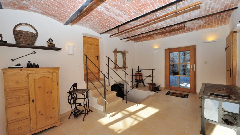Interior with vaulted ceiling, wooden furniture and antique objects.