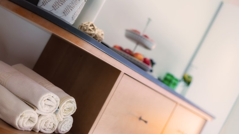 A wellness area with towels and a buffet with fruit.