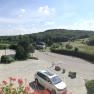 Panoramic view of a rural landscape with hills and meadows from a hotel balcony.