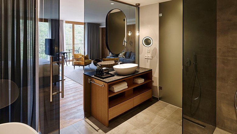 Modern hotel room with open bathroom and shower.