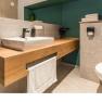 Modern bathroom with wooden washbasin, washbasin, towel rail and toilet.