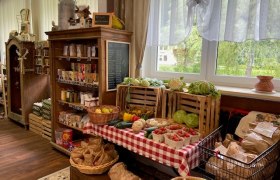 Interior view of a farm store with fruit and vegetables.