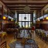 Interior view of a restaurant with wooden furniture and large windows.