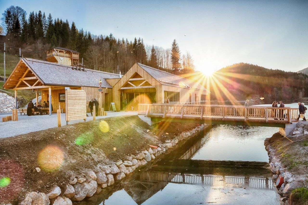 Ötscher base Wienerbruck with wooden buildings and bridge at sunset.