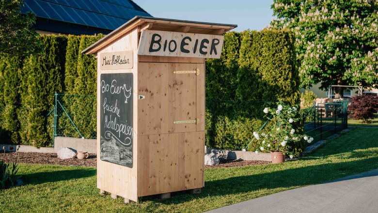 Organic eggs and fresh pastries are advertised on a sign outside the small Holzhof store directly in front of the Wieserhof farm