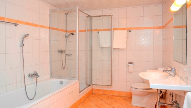 Modern bathroom with bathtub, shower, washbasin and toilet.