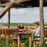 Two people clink glasses of wine on an outdoor terrace.