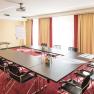 Conference room with U-shaped table, chairs, flipchart and projector.