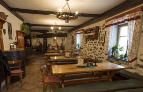 Cozy dining room with wooden tables and stone walls.