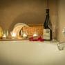 Romantic bathroom with candles, wine bottle and rose petals on the edge of the bathtub.