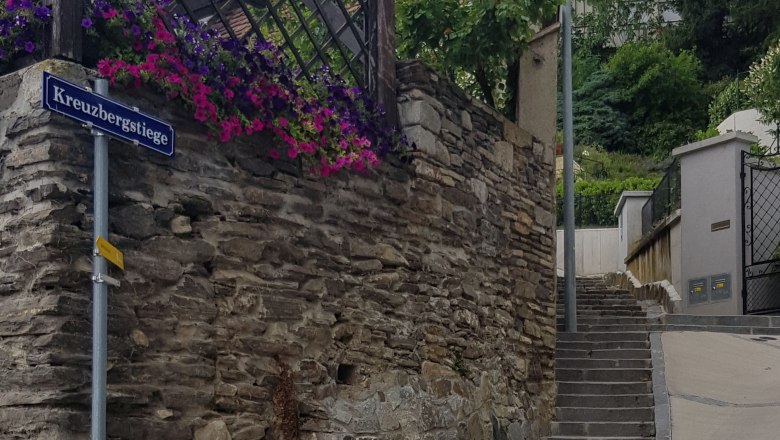 Stone staircase with flowers and street sign 'Kreuzbergstiege' in Krems.