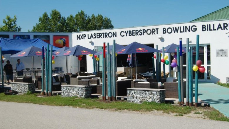 Exterior view of a leisure center with umbrellas and seating.