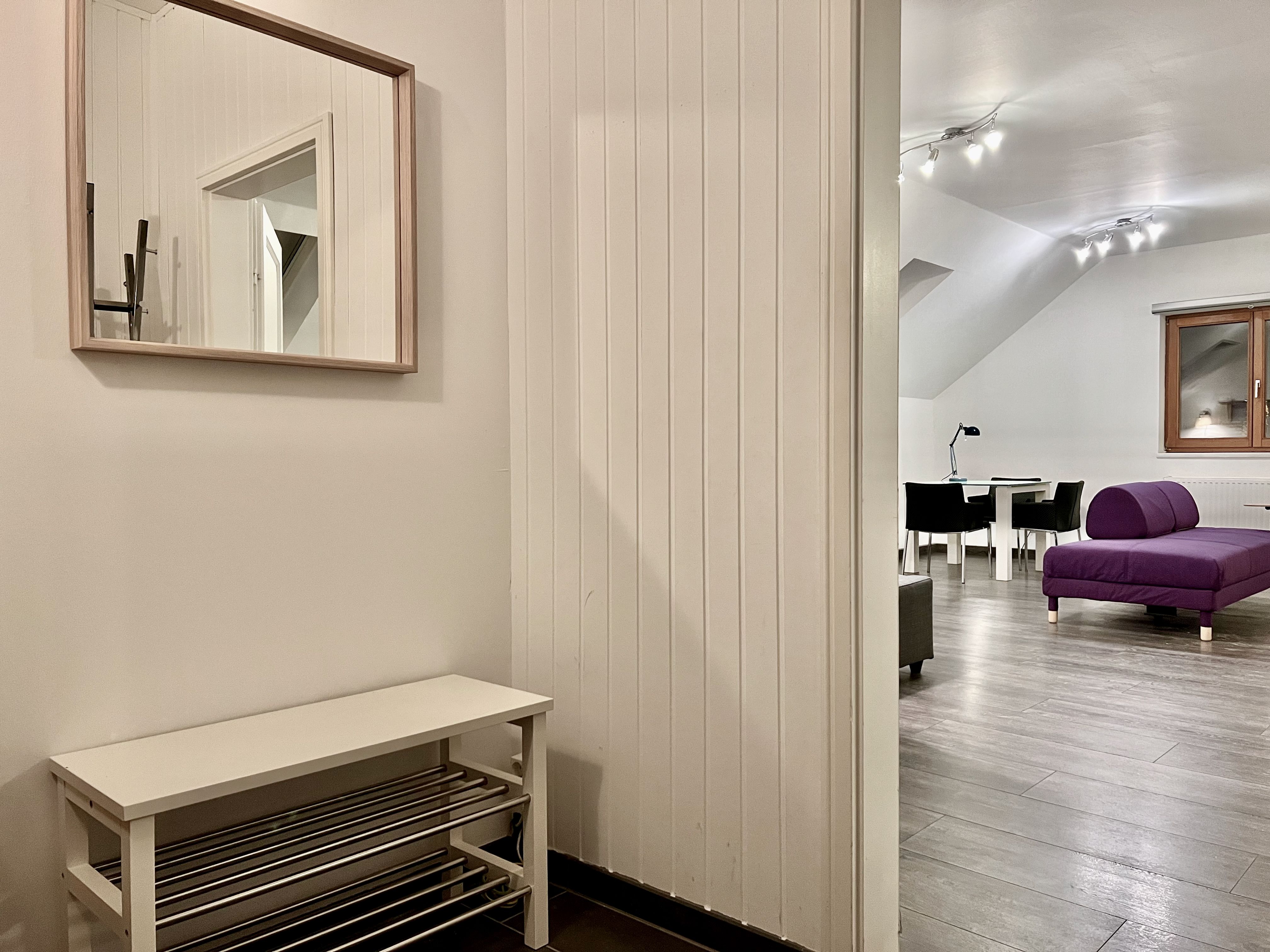 Interior view of a modern loft with purple sofa and dining table.