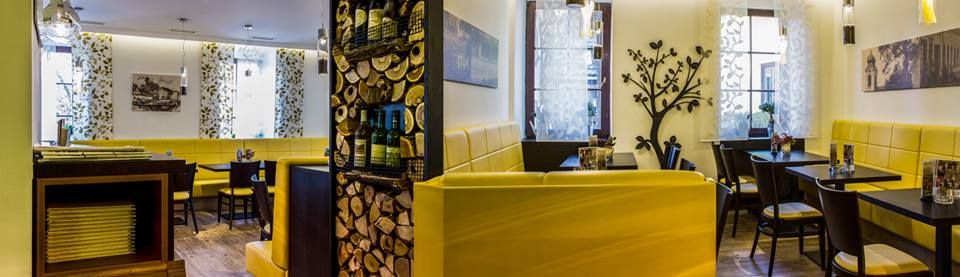 Interior view of a restaurant with yellow benches and decorative elements.