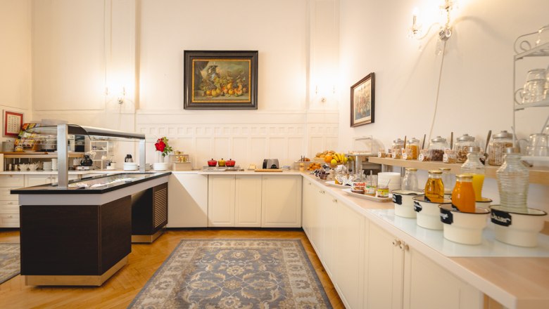 Breakfast buffet in a hotel with a variety of food and drinks.