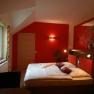Cozy bedroom with red wall and double bed.