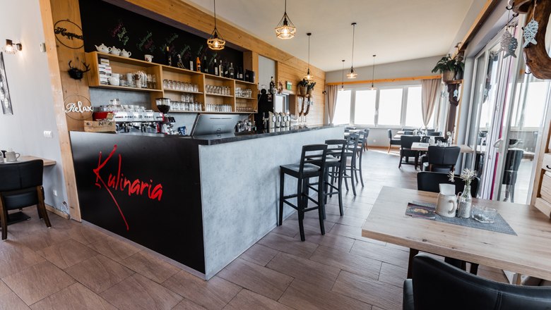 Interior view of a modern restaurant with bar and seating area.