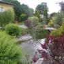 A well-tended garden with a pond, fountain and lush vegetation.