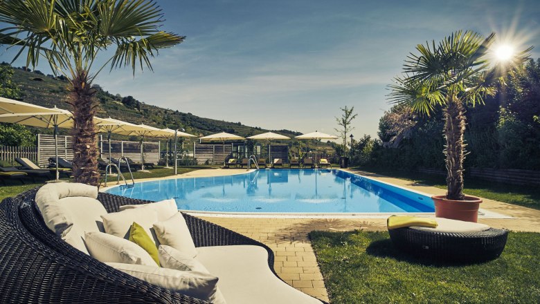Outdoor pool at the Steigenberger Krems with sun loungers and parasols.
