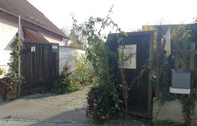 Entrance gate to a vineyard with plants and flowers.
