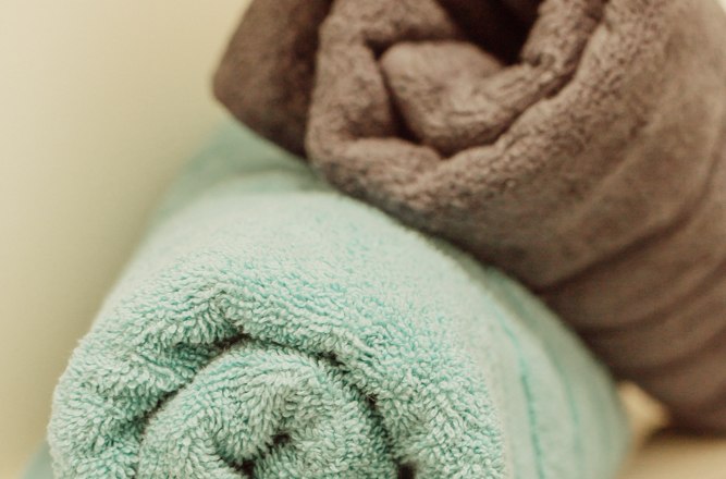 Two rolled-up towels, one in turquoise and one in brown, lie on a shelf.