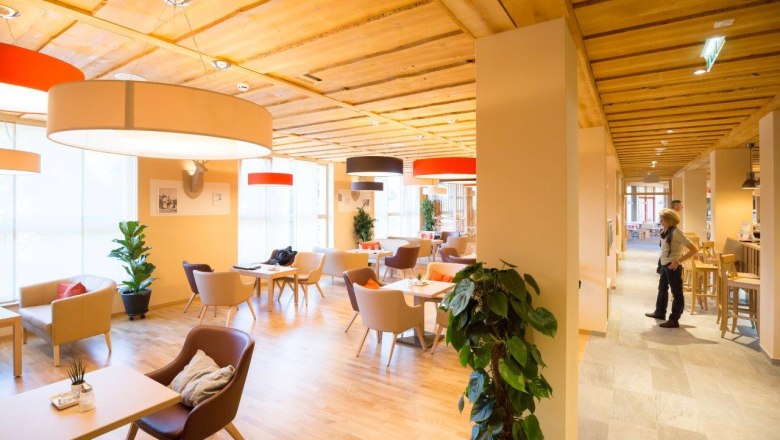 Lobby of the JUFA Hotel Annaberg with modern furniture and large lamps.