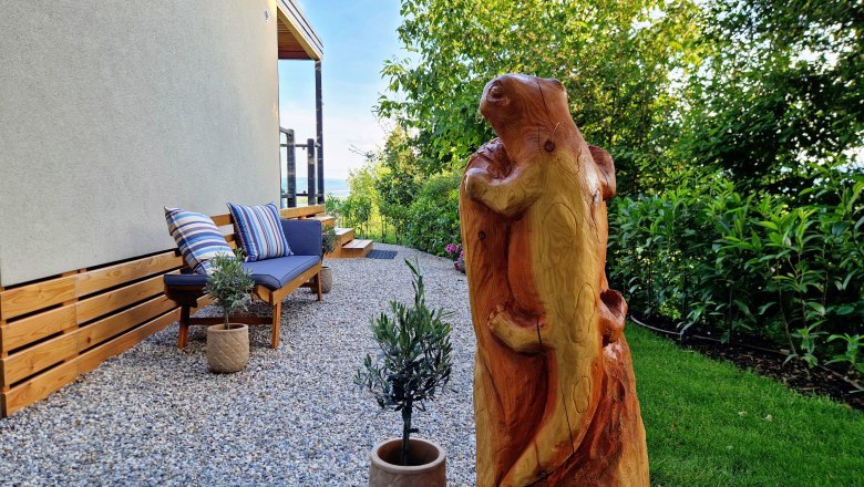 Garden area with wooden sculpture and bench at Chalet Salamander.