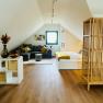 Cozy attic apartment with sofa, bed and wooden floor.