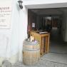 Entrance to a winery with wine barrel and bottles.