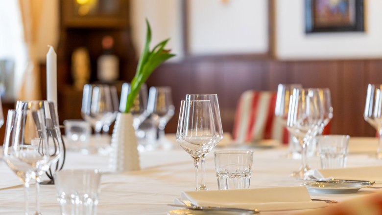 Elegant table at the Hotel Post with wine glasses, candle and flower vase.