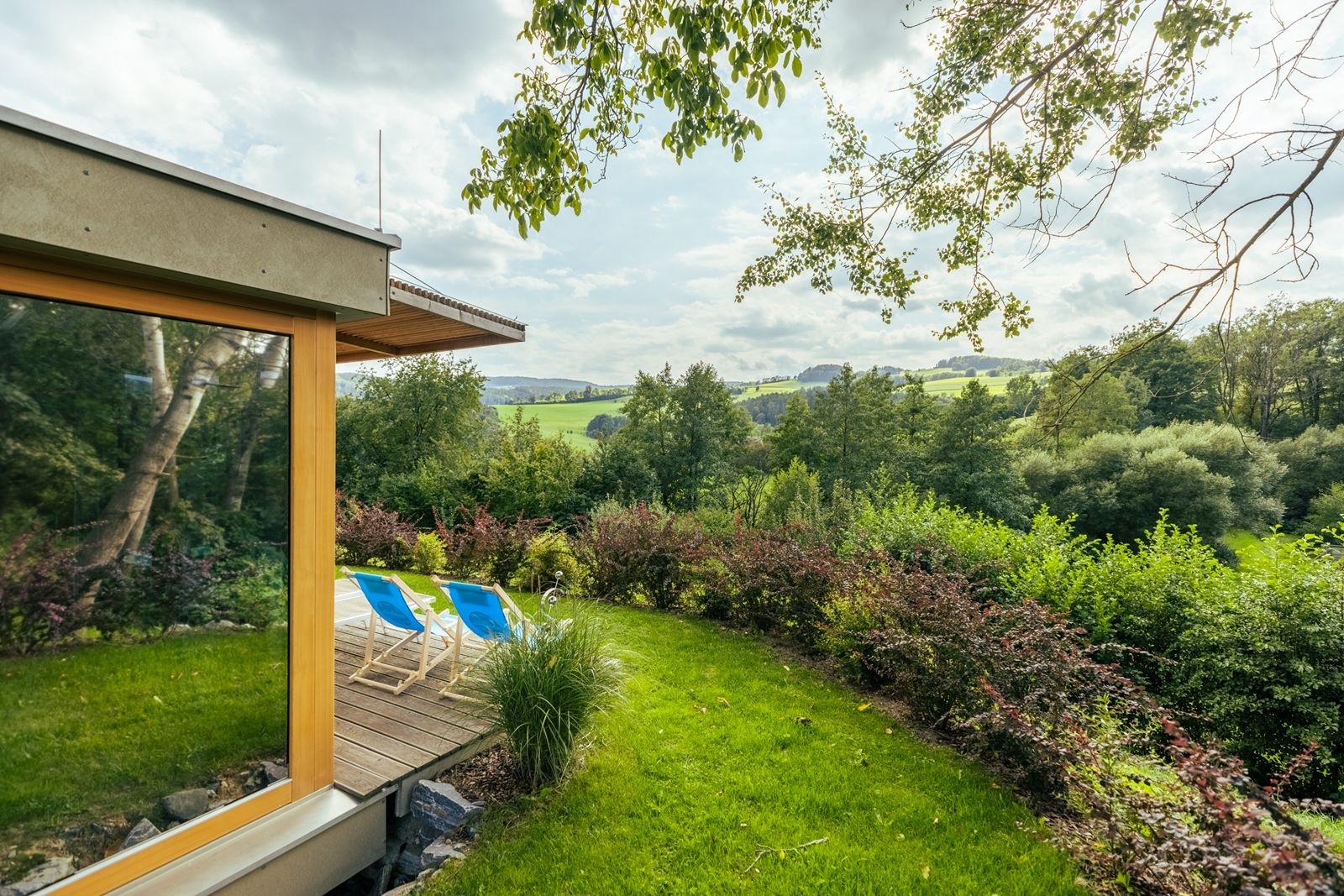 Garden with sun loungers and views of a green landscape.