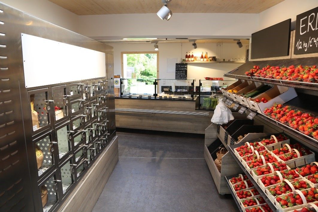 Interior view of a farm store with vending machines and fresh strawberries.