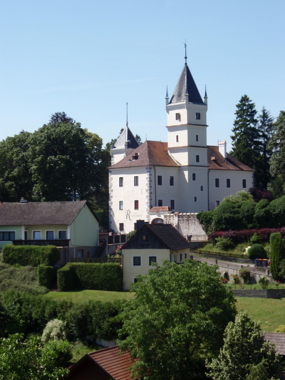 Rothenhof Castle in Emmersdorf surrounded by trees and buildings.