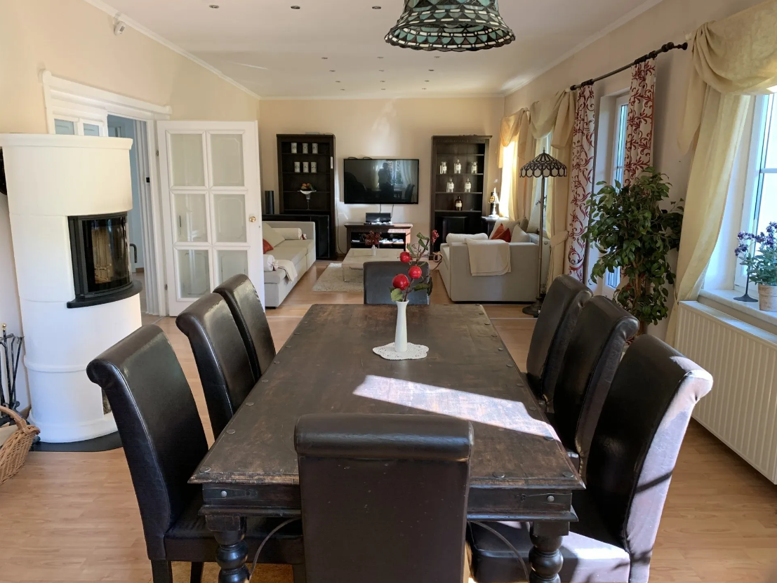 Large, cozy living room with two sofas and a large wooden dining table for at least 8 people