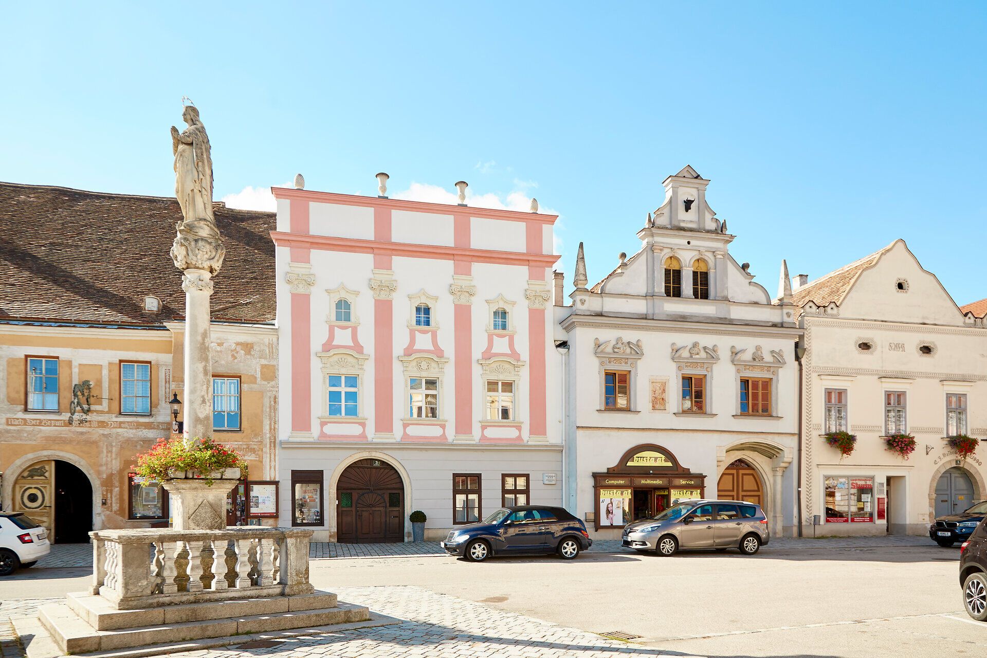 Historic buildings on Eggenburg's main square with a statue in the foreground.