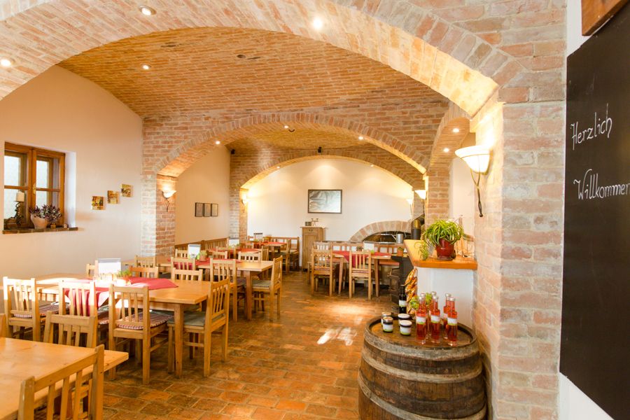 Interior view of a cozy wine tavern with wooden tables and brick walls.