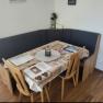 Dining area with corner bench and table in a vacation apartment.