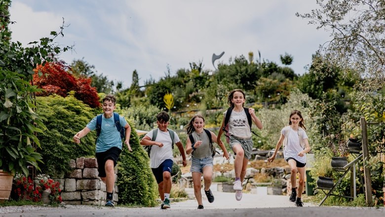 Five children run happily along a garden path in the Kittenberg Adventure Gardens.