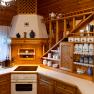 Rustic wooden kitchen with shelves, crockery and spice containers.