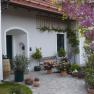 Entrance to a country house with flowering plants and a barrel.