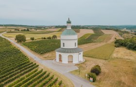 Aerial view of the Rochus Chapel on the Rochusberg in Mannersdorf, surrounded by vineyards and fields.