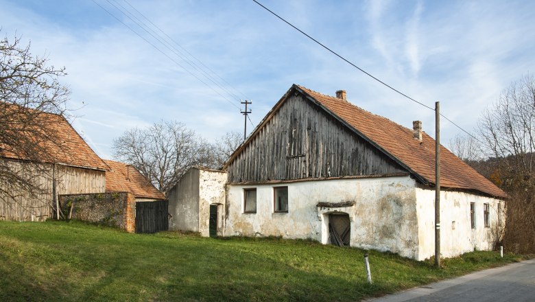 Old buildings in the Sieghartskirchen wine cellar lane with red tiled roofs and weathered facades.