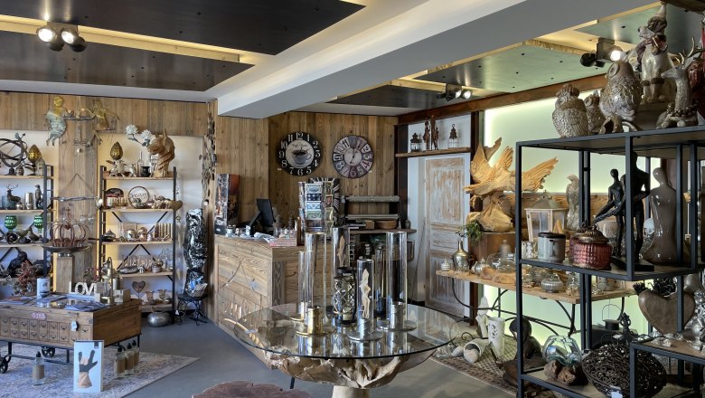 Interior view of a decoration store with wooden shelves and various decorative items.