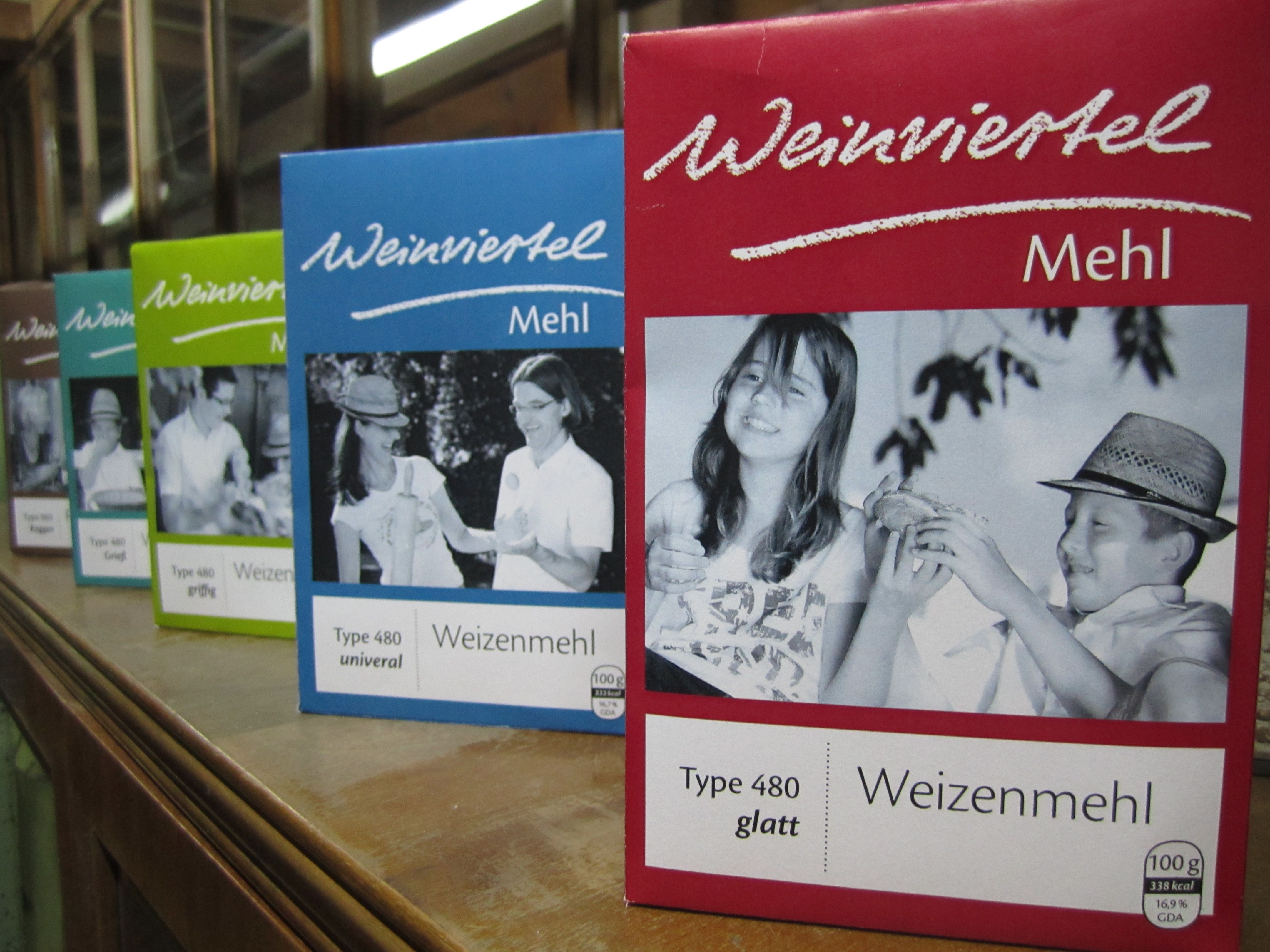 Various packs of Weinviertel flour in a row on a shelf.